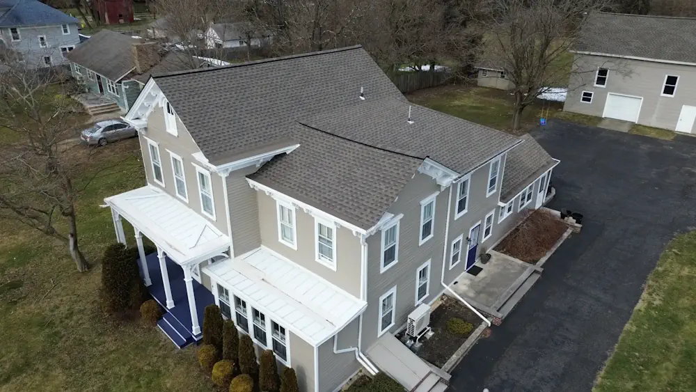 Large farmhouse-style home with professional white gutter and downspout system installation